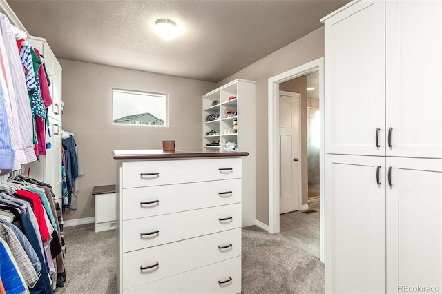 walk in closet featuring light colored carpet