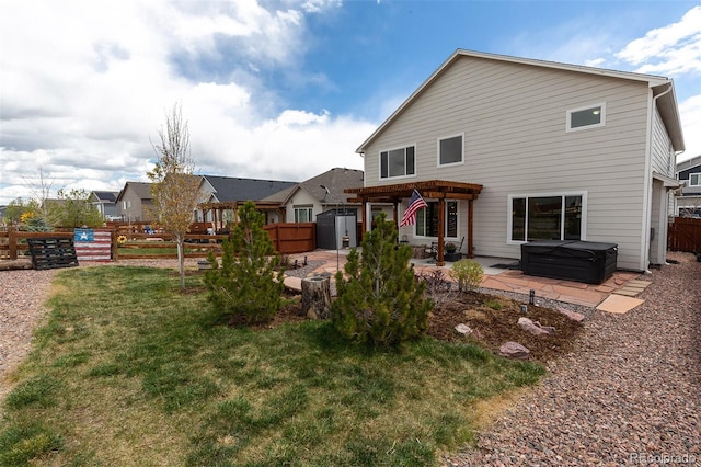rear view of property featuring a patio, a pergola, a hot tub, a fenced backyard, and a shed