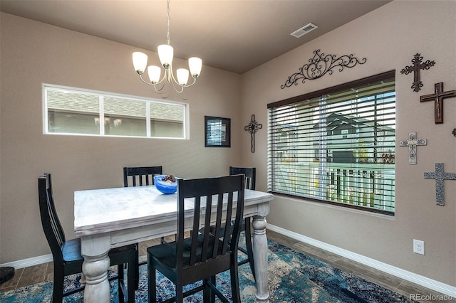 dining room with baseboards, an inviting chandelier, visible vents, and wood finished floors