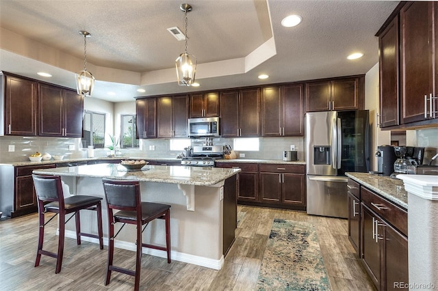 kitchen featuring light wood-style floors, a textured ceiling, visible vents, and appliances with stainless steel finishes