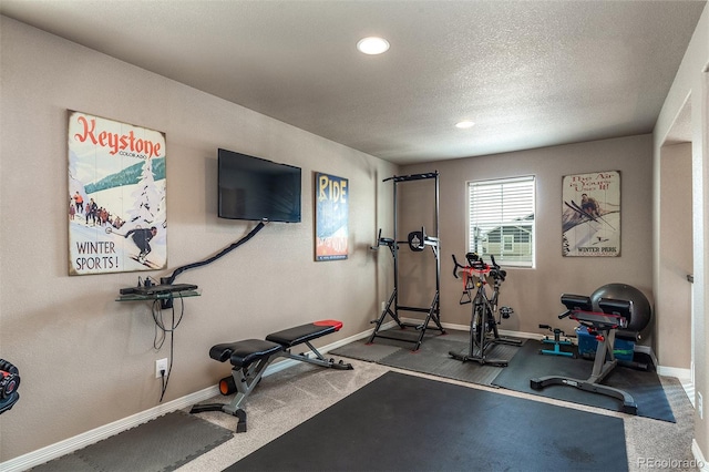 workout room with baseboards, recessed lighting, and a textured ceiling