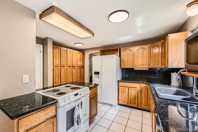 3150 Lane Ct, Boulder, CO 80305 - kitchen featuring white appliances, a sink, a textured ceiling, light tile patterned floors, and brown cabinets