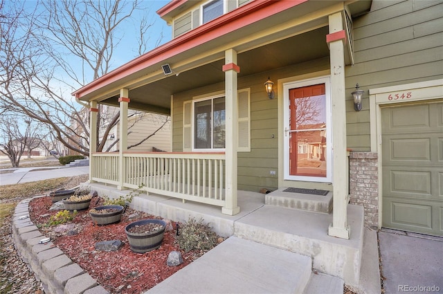 property entrance with a garage and covered porch