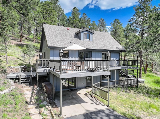 30221 Marge Ln, Evergreen, CO 80439 - view of front facade with a shingled roof, a wooden deck, stairs, and view of scattered trees