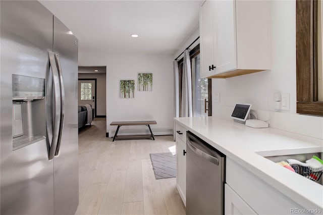 30221 Marge Ln, Evergreen, CO 80439 - kitchen with appliances with stainless steel finishes, light countertops, white cabinetry, light wood-type flooring, and recessed lighting