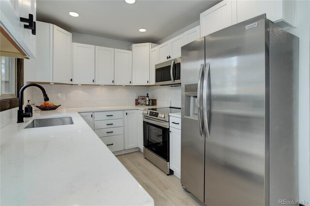 30221 Marge Ln, Evergreen, CO 80439 - kitchen with appliances with stainless steel finishes, light countertops, light wood-style flooring, recessed lighting, and white cabinets
