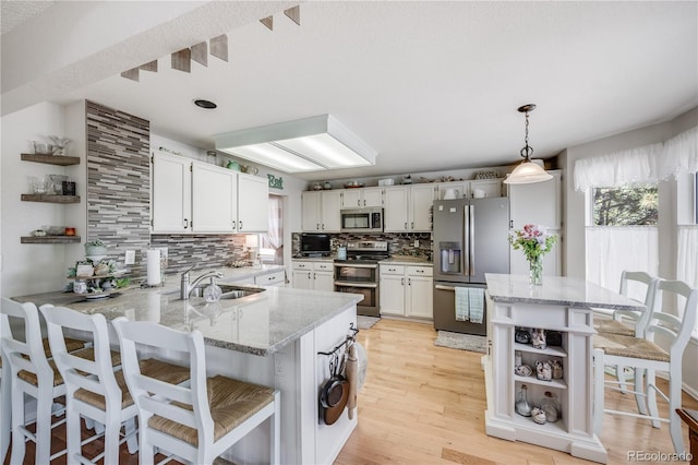 11760 Eudora Ct, Thornton, CO 80233 - kitchen with appliances with stainless steel finishes, open shelves, a peninsula, backsplash, and healthy amount of natural light