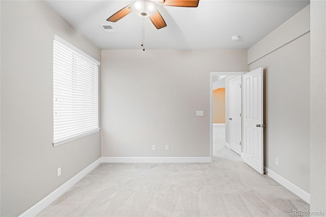 empty room featuring ceiling fan and light colored carpet