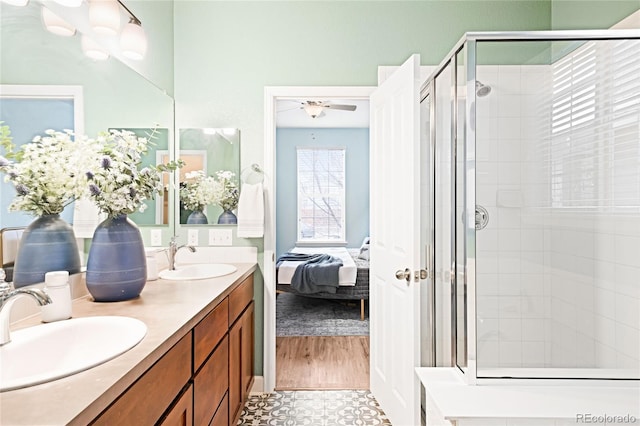 bathroom featuring ceiling fan, an enclosed shower, and vanity