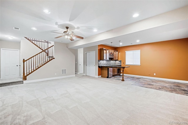 unfurnished living room featuring light colored carpet and ceiling fan