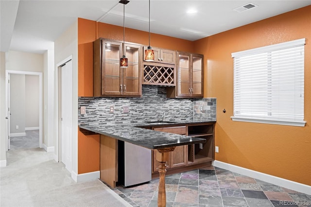 bar featuring sink, tasteful backsplash, and hanging light fixtures