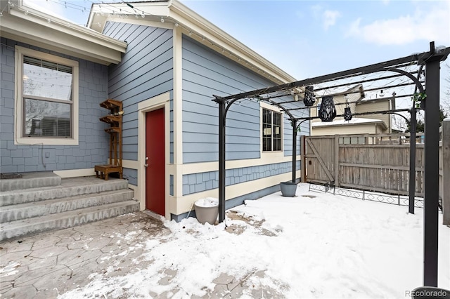 view of snowy exterior featuring a pergola