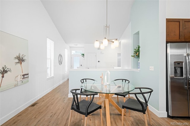 dining area featuring light wood-style flooring, baseboards, visible vents, and a chandelier