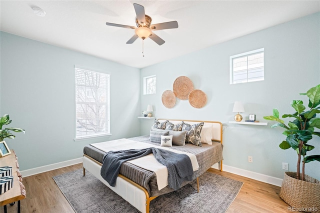 bedroom featuring multiple windows, wood finished floors, and baseboards