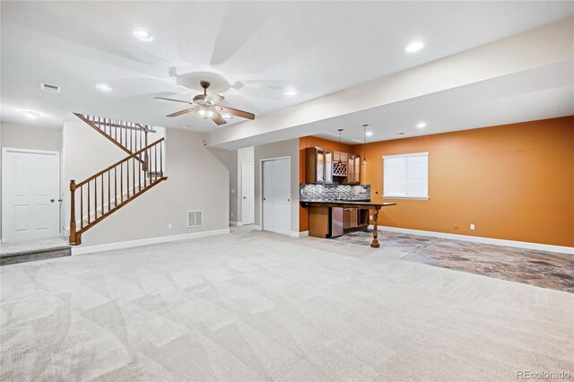 unfurnished living room featuring light carpet, stairway, and visible vents