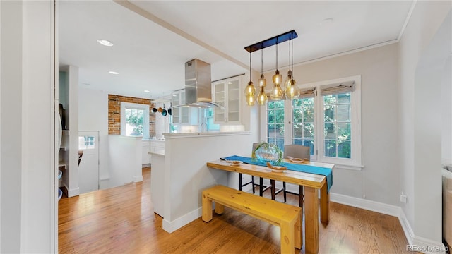 dining space with ornamental molding, a chandelier, and light wood-type flooring