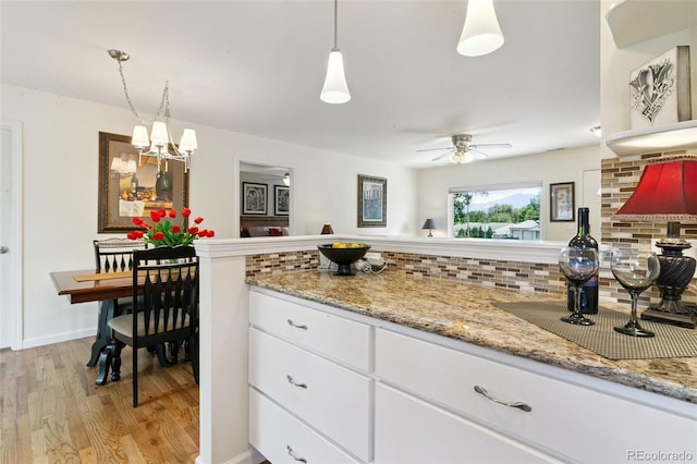 4803 N Weber St, Colorado Springs, CO 80907 - kitchen featuring light wood finished floors, white cabinets, decorative backsplash, a ceiling fan, and light stone counters