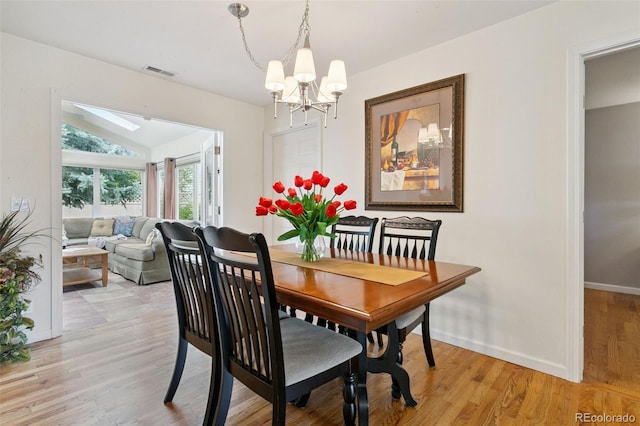 4803 N Weber St, Colorado Springs, CO 80907 - dining room with a chandelier, vaulted ceiling, light wood-style flooring, and a skylight
