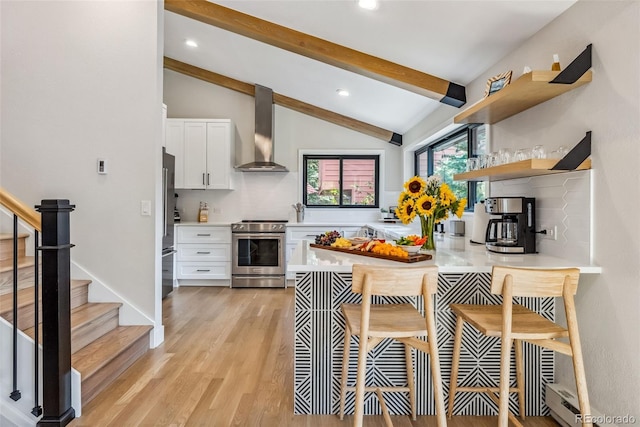 249 E Coyote Ct, Silverthorne, CO 80498 - kitchen featuring appliances with stainless steel finishes, wall chimney exhaust hood, white cabinets, light countertops, and open shelves