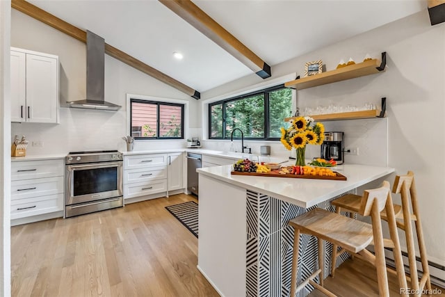 249 E Coyote Ct, Silverthorne, CO 80498 - kitchen with stainless steel appliances, wall chimney exhaust hood, white cabinetry, a peninsula, and recessed lighting