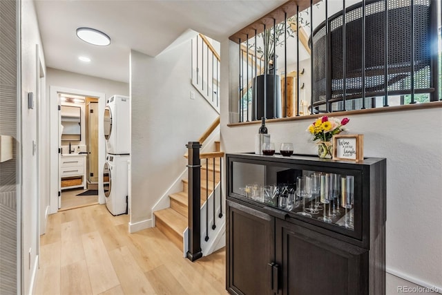 249 E Coyote Ct, Silverthorne, CO 80498 - corridor featuring stacked washer / dryer, light wood-style floors, and stairs