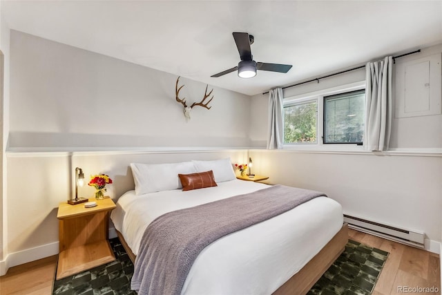 249 E Coyote Ct, Silverthorne, CO 80498 - bedroom with baseboard heating, wood finished floors, and a ceiling fan