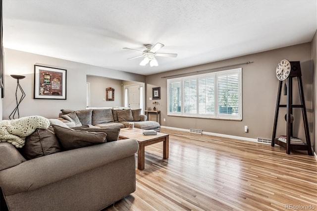 living room with light wood-type flooring and ceiling fan