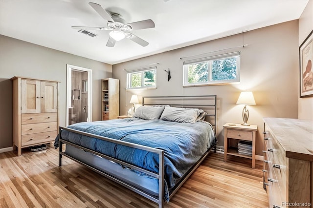 bedroom with ceiling fan, connected bathroom, and light hardwood / wood-style flooring