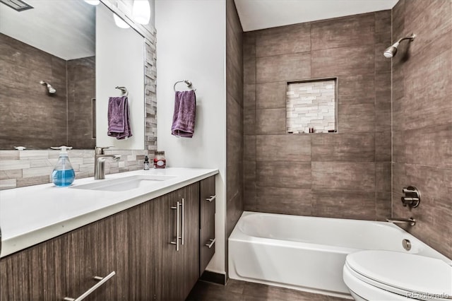 full bathroom featuring tiled shower / bath combo, toilet, tasteful backsplash, and vanity