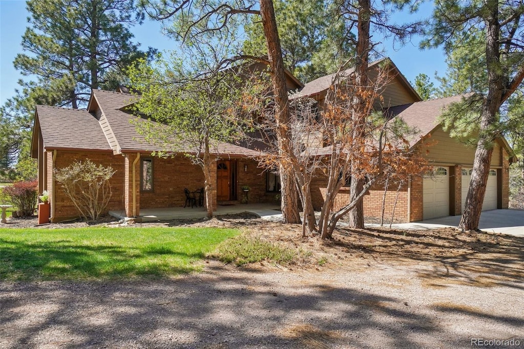 1332 Meadow Trl, Franktown, CO 80116 - view of front of house with roof with shingles, driveway, covered porch, and a garage