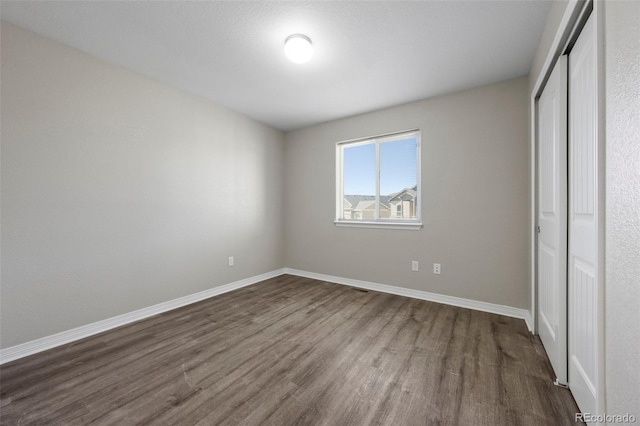 unfurnished bedroom featuring a closet and hardwood / wood-style floors