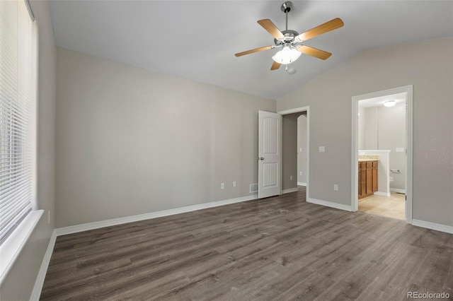 unfurnished bedroom with dark hardwood / wood-style flooring, ceiling fan, ensuite bath, and vaulted ceiling