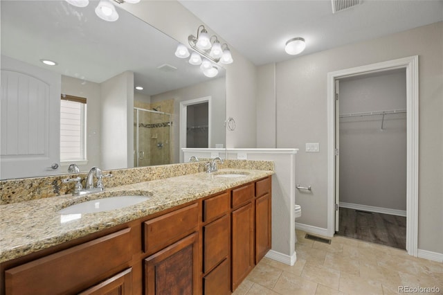 bathroom featuring toilet, tile patterned floors, vanity, and a shower with door