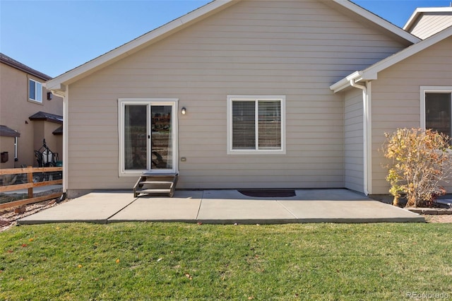 rear view of house with a patio and a yard