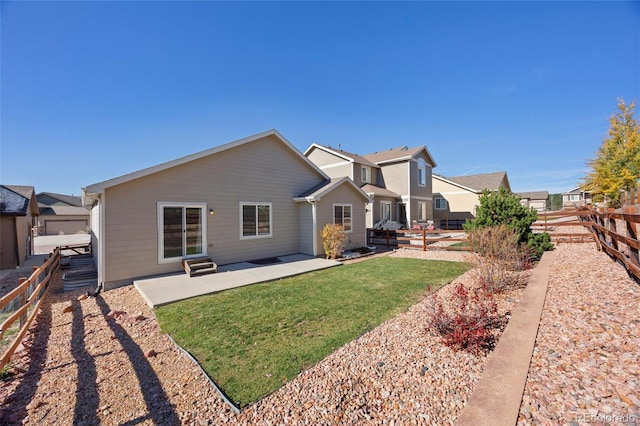 back of property featuring a hot tub, a patio area, and a lawn