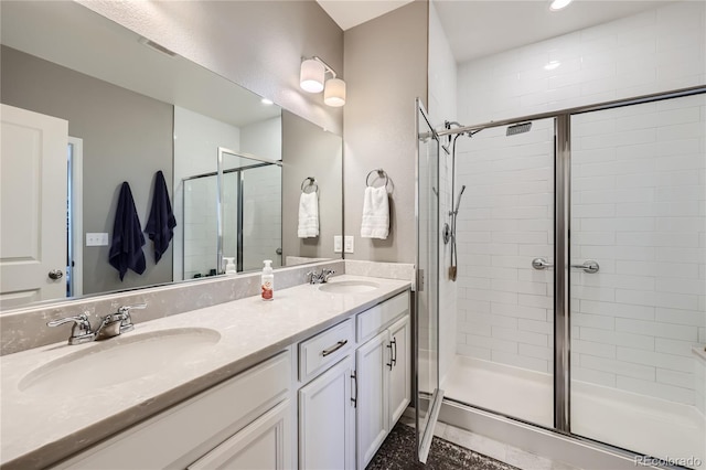 bathroom featuring an enclosed shower, dual bowl vanity, and tile patterned flooring