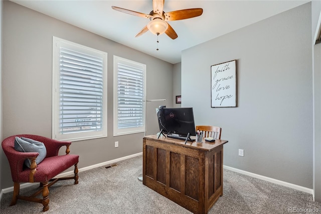 carpeted office space featuring ceiling fan