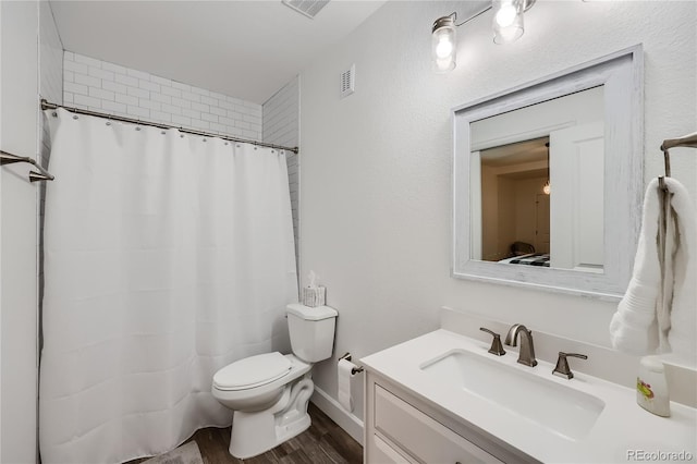 bathroom with vanity, toilet, and hardwood / wood-style floors