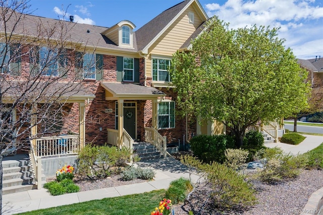 townhome / multi-family property featuring brick siding and a shingled roof