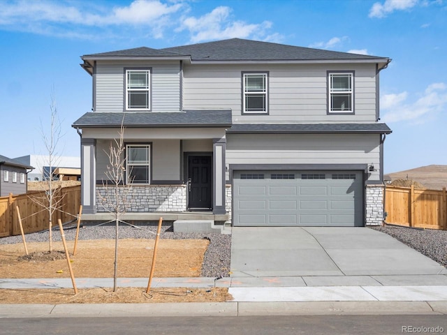 traditional-style home featuring covered porch, a garage, fence, stone siding, and driveway