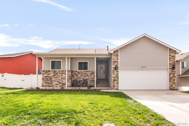 519 N 28th Avenue Ct, Greeley, CO 80631 - view of front facade with driveway, brick siding, an attached garage, and a porch