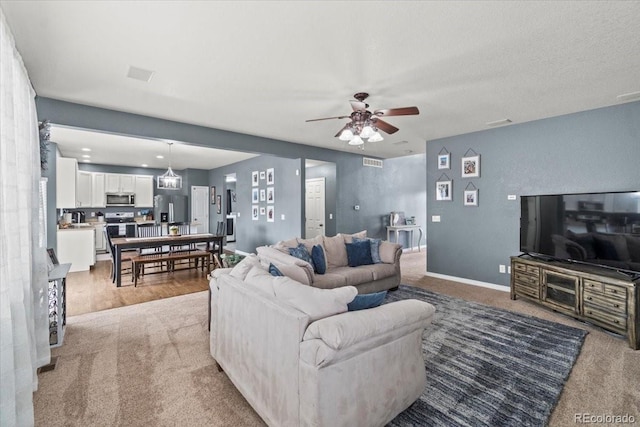 5404 Fawn Ridge Way, Castle Rock, CO 80104 - living room featuring light colored carpet, ceiling fan, and baseboards