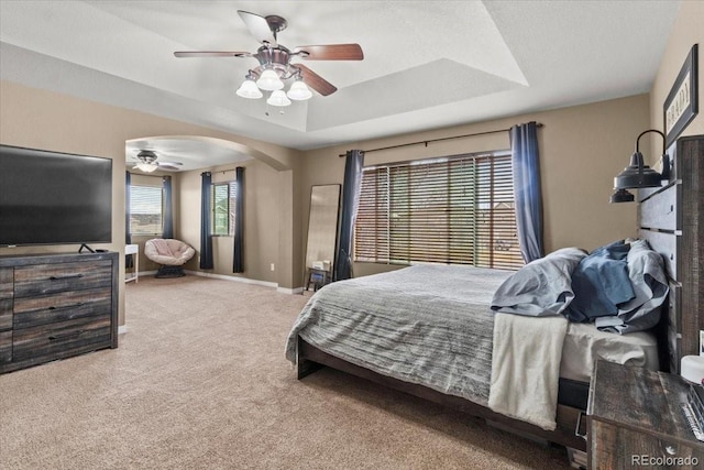 5404 Fawn Ridge Way, Castle Rock, CO 80104 - carpeted bedroom with a raised ceiling, arched walkways, baseboards, and ceiling fan