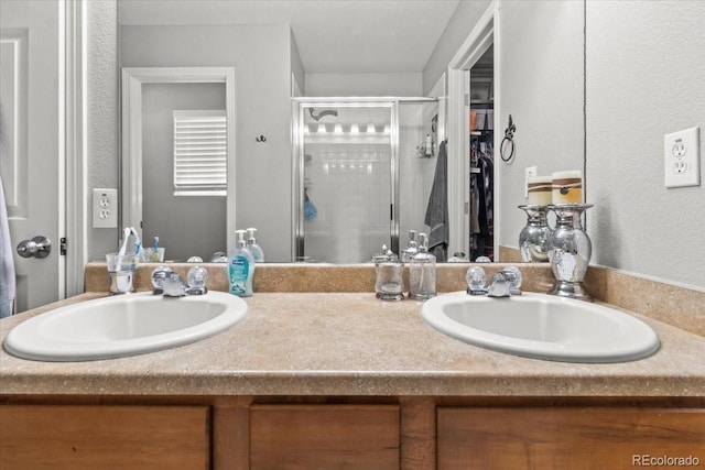 5404 Fawn Ridge Way, Castle Rock, CO 80104 - bathroom featuring double vanity, a shower stall, and a spacious closet
