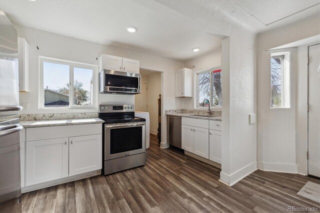 4401 W Mississippi Ave, Denver, CO 80219 - kitchen with appliances with stainless steel finishes, a sink, dark wood-style floors, white cabinetry, and baseboards