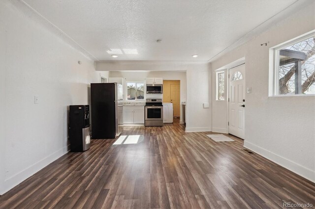 4401 W Mississippi Ave, Denver, CO 80219 - unfurnished living room featuring baseboards, dark wood finished floors, a textured ceiling, and crown molding