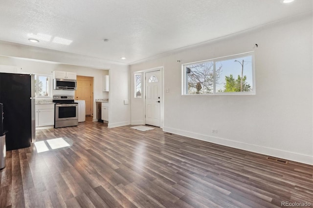 4401 W Mississippi Ave, Denver, CO 80219 - unfurnished living room featuring plenty of natural light, baseboards, dark wood finished floors, a textured ceiling, and recessed lighting