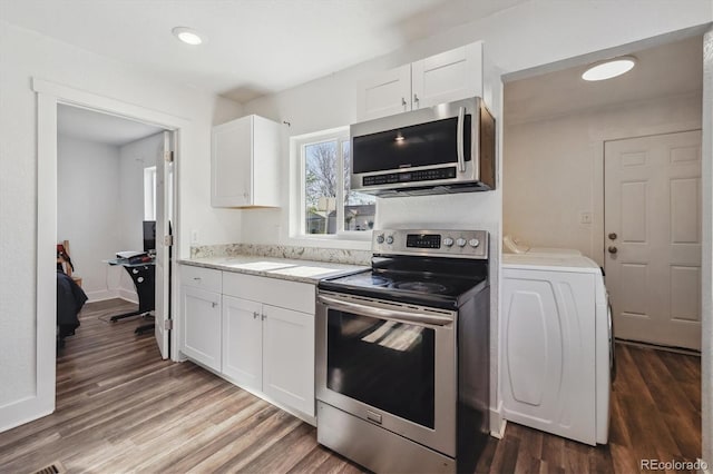 4401 W Mississippi Ave, Denver, CO 80219 - kitchen with appliances with stainless steel finishes, washer / clothes dryer, dark wood-style flooring, white cabinetry, and recessed lighting