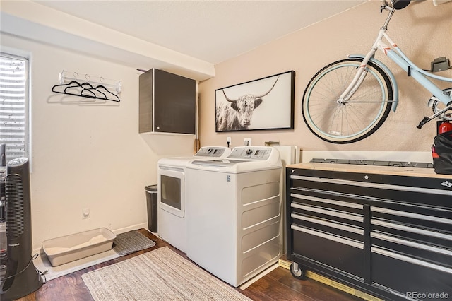 laundry area with cabinets, dark wood-type flooring, and washing machine and clothes dryer