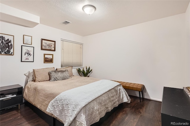 bedroom featuring a textured ceiling and dark hardwood / wood-style floors